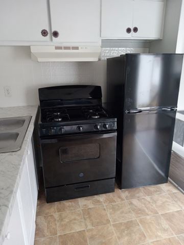 Louisville house for rent - A black stove and refrigerator in a kitchen.