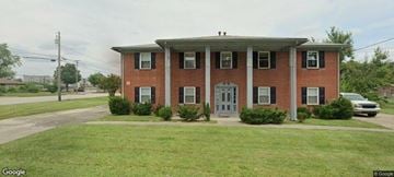 Louisville apartment for rent - A red brick house with a grey door and windows.