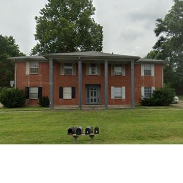 Louisville apartment for rent - A red brick building with a grey roof and a mailbox in front.