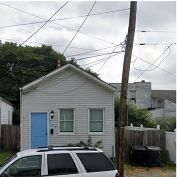 Louisville house for rent - A small house with a blue door and a car parked in front.