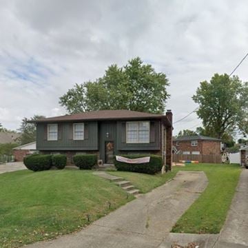 Louisville house for rent - A green house with a brown roof and a white fence in front.