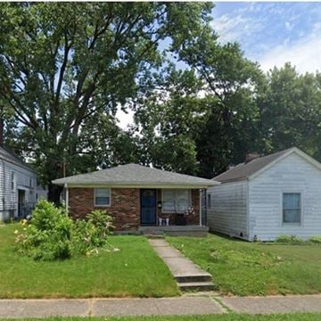 Louisville house for rent - A house with a brick front and a porch is surrounded by greenery.