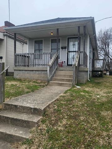 Louisville house for rent - A house with a grey siding and a porch with a red chair.