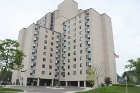 Minneapolis apartment for rent - A large beige building with a flag on the right side.
