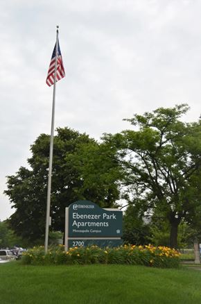 Minneapolis apartment for rent - A sign for Ebenzer Park Apartments is in front of a flag pole.