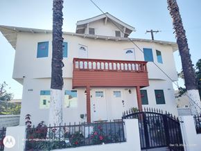 Los Angeles apartment for rent - A white house with a red balcony and a black gate.