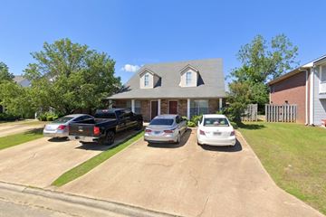 Tupelo apartment for rent - A house with a grey roof and a white car parked in front.