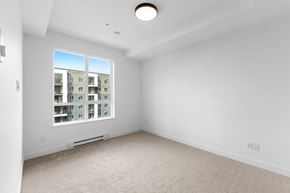 Langley house for rent - A spacious, empty room with a large window overlooking a building.