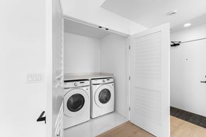 Langley house for rent - A laundry room with two washing machines and a door open.