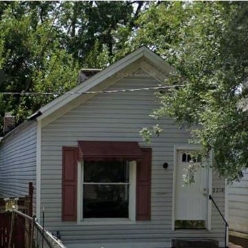 Louisville house for rent - A small house with a red window trim and a white door.