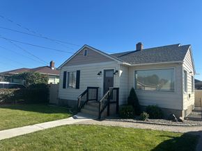 Sunnyside house for rent - A house with a grey roof and a white wall with a black railing.