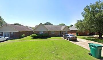 Tupelo house for rent - A residential area with houses and cars.