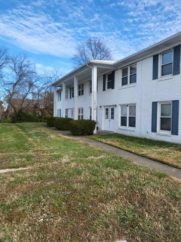 Louisville apartment for rent - A white two-story building with blue trim and a small front yard.