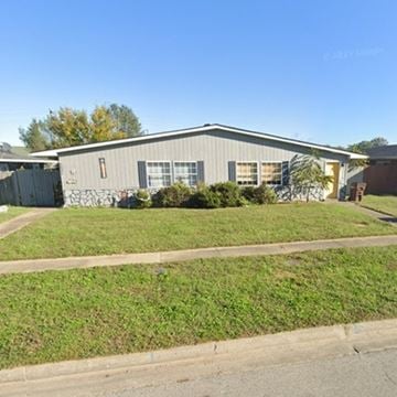 Louisville house for rent - A grey building with a green lawn in front.