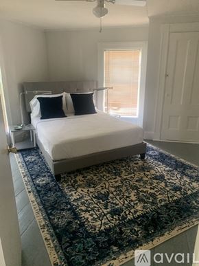 Calais apartment for rent - A bedroom with a large bed and a patterned rug.