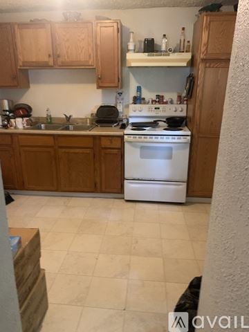 Calais apartment for rent - A kitchen with a white stove top oven and wooden cabinets.