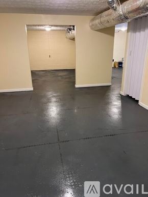 La Follette house for rent - A spacious room with a grey floor and a white door.