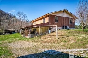 La Follette house for rent - A house with a brown and beige exterior is surrounded by a grassy area and trees.