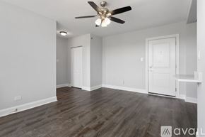 Chicago apartment for rent - A room with a ceiling fan and wooden flooring.