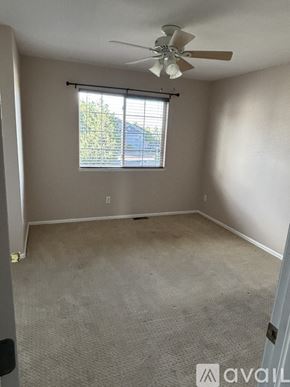 Aurora townhouse for rent - A bedroom with a bed, dresser, and ceiling fan.