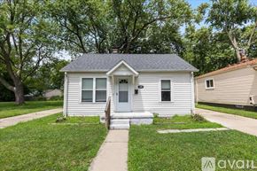 Hazel Park house for rent - A small white house with a grey roof and a front porch.