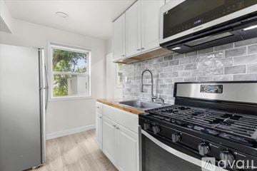 Hazel Park house for rent - A kitchen with a stove top oven and a refrigerator.