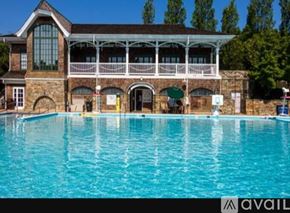 Gaithersburg house for rent - A large swimming pool in front of a building with a balcony.