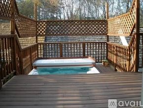 Gaithersburg house for rent - A wooden deck with a hot tub in the middle.
