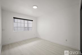 Los Angeles apartment for rent - A spacious room with a window and wooden flooring.