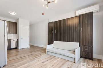 Chicago apartment for rent - A living room with a white couch and wooden floors.