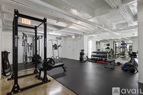 Chicago apartment for rent - A gym with a variety of equipment including a squat rack, bench, and weights.