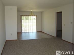 Tomah apartment for rent - A room with a carpeted floor and a chandelier hanging from the ceiling.