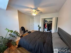 Chicago apartment for rent - A bedroom with a bed, a ceiling fan, and a wardrobe.