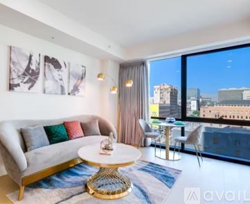 Los Angeles condo for rent - A living room with a white couch and a round table with a gold base.