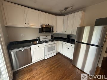 Boston condo for rent - A kitchen with white cabinets and a stainless steel refrigerator.