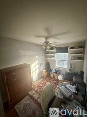 Boston condo for rent - A room with a ceiling fan and a rug on the floor.