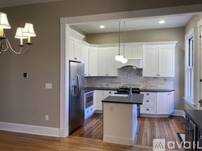 Newport house for rent - A kitchen with a refrigerator, stove, and cabinets.