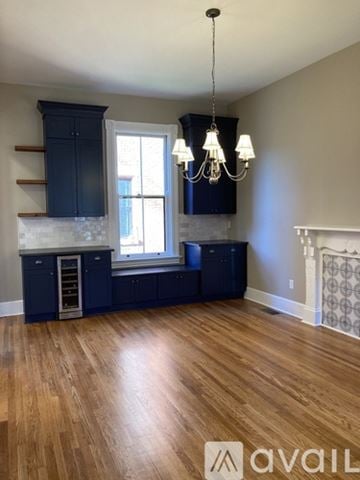 Newport house for rent - A kitchen with dark blue cabinets and a wooden floor.