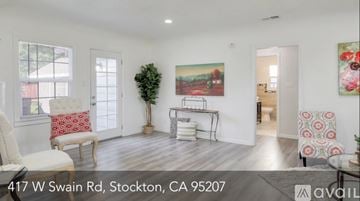 Stockton house for rent - A living room with a white couch and a painting on the wall.