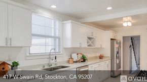 Stockton house for rent - A modern kitchen with white cabinets and a stainless steel refrigerator.