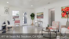 Stockton house for rent - A living room with a sofa, a chair, a table, and a painting on the wall.