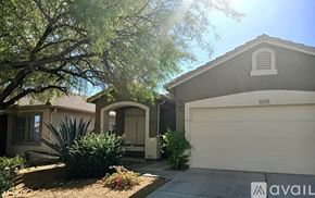 Phoenix house for rent - A house with a garage and a tree in front of it.