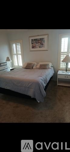 Phoenix house for rent - A bedroom with a bed, nightstands, and a painting on the wall.