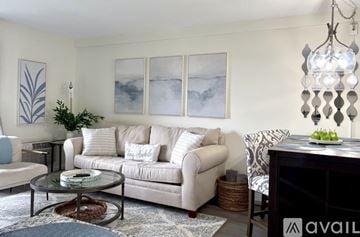 Laconia condo for rent - A living room with a white couch and a glass coffee table.