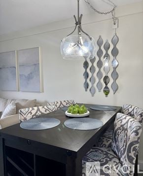 Laconia condo for rent - A modern dining room with a glass chandelier and a black dining table.