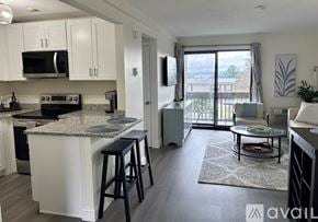Laconia condo for rent - A kitchen with white cabinets and a granite countertop.