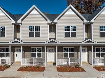 Manchester apartment for rent - A row of houses with white fences and front yards.