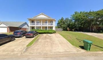 Tupelo apartment for rent - A house with a carport and a green trash can.