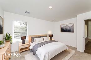 Oklahoma City house for rent - A bedroom with a bed, nightstand, and a painting on the wall.