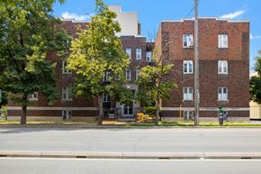 Ottawa apartment for rent - A red brick building with trees in front.